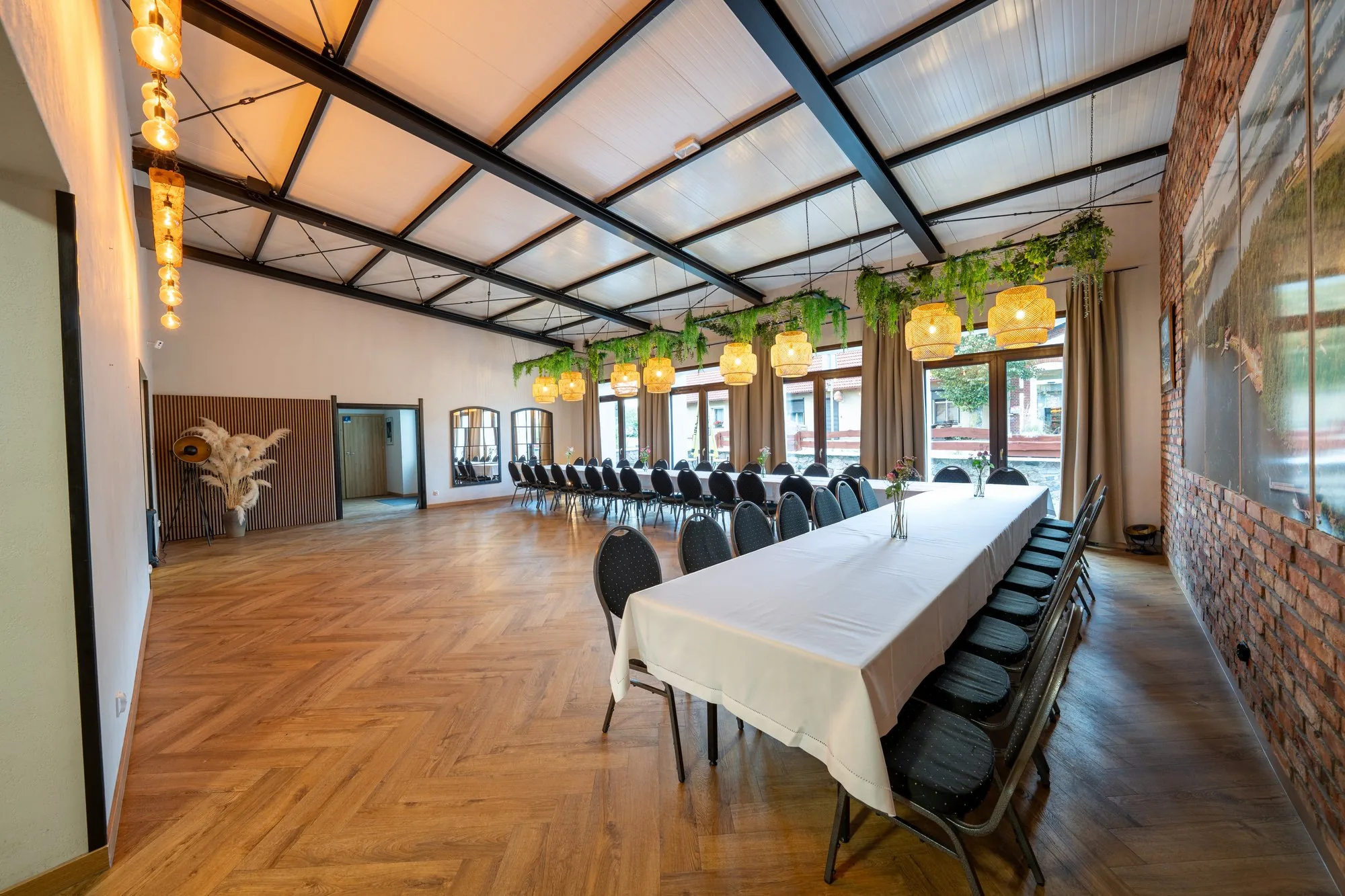Sala z długimi stołami nakrytymi białymi obrusami